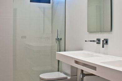 Modern bathroom with a curbless shower, white tile, porcelain tile, white walls, porcelain floors, an integrated sink and brown floor.