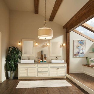 Idée de décoration pour une grande salle de bain principale marine avec une vasque, un placard à porte persienne, des portes de placard beiges, un plan de toilette en granite, un mur beige et un sol en carrelage de céramique.