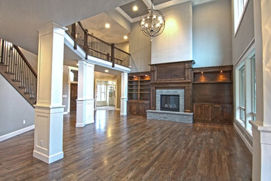 Large traditional formal open concept living room in Portland with grey walls, a standard fireplace, a stone fireplace surround, a built-in media wall and medium hardwood floors.