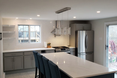 Kitchen pantry - mid-sized modern vinyl floor and gray floor kitchen pantry idea in Other with shaker cabinets, gray cabinets, quartz countertops, white backsplash, ceramic backsplash, stainless steel appliances, an island, multicolored countertops and a drop-in sink