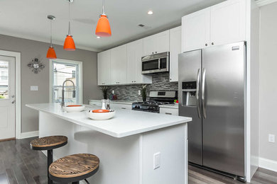 Inspiration for a mid-sized contemporary galley medium tone wood floor eat-in kitchen remodel in Baltimore with an undermount sink, shaker cabinets, white cabinets, quartz countertops, multicolored backsplash, matchstick tile backsplash, stainless steel appliances and an island