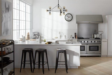 Inspiration for a mid-sized contemporary u-shaped light wood floor and beige floor kitchen remodel in New York with a farmhouse sink, flat-panel cabinets, white cabinets, quartz countertops, a peninsula and white countertops