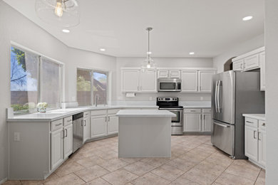 Large minimalist u-shaped eat-in kitchen photo in Phoenix with an undermount sink, shaker cabinets, white cabinets, quartz countertops, stainless steel appliances, an island and white countertops