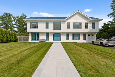 Inspiration for a huge 1950s white two-story wood and board and batten gable roof remodel in New York with a shingle roof and a blue roof