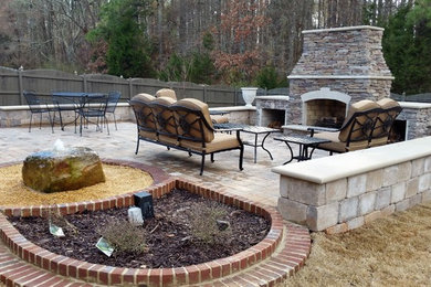 Elegant backyard concrete paver patio photo in Other with a fire pit
