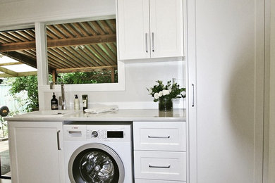 Photo of a small traditional single-wall laundry room in Adelaide with a drop-in sink, shaker cabinets, white cabinets, laminate benchtops, white walls and porcelain floors.