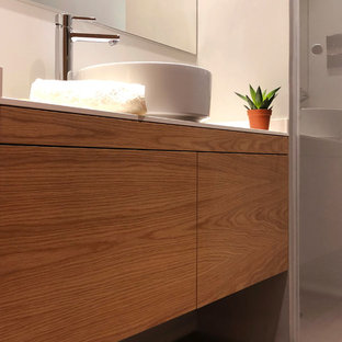 Esempio di una stanza da bagno padronale minimalista di medie dimensioni con ante lisce, ante in legno scuro, doccia a filo pavimento, piastrelle grigie, piastrelle di cemento, pareti grigie, pavimento in cemento, lavabo a bacinella, top in quarzo composito, pavimento grigio, porta doccia a battente e top bianco