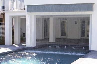 Pool fountain - large modern backyard concrete paver and rectangular pool fountain idea in Orlando