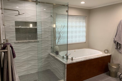 Example of a large minimalist master gray tile and glass tile porcelain tile and gray floor bathroom design with shaker cabinets, white cabinets, gray walls, an undermount sink, granite countertops and a hinged shower door