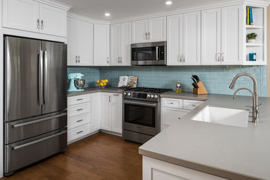 Inspiration for a transitional u-shaped medium tone wood floor kitchen remodel in San Diego with an undermount sink, shaker cabinets, white cabinets, blue backsplash, subway tile backsplash, stainless steel appliances, a peninsula and gray countertops