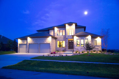 Inspiration for a large contemporary two-story stone exterior home remodel in Other with a hip roof