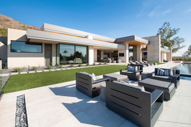 Inspiration for a large contemporary backyard tile patio remodel in Phoenix with a fire pit and no cover