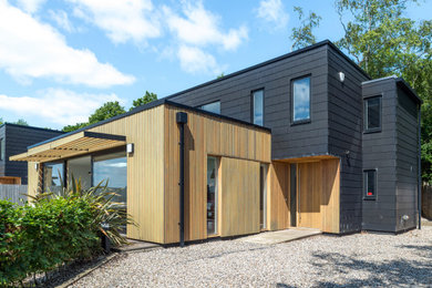 Mittelgroßes Modernes Einfamilienhaus mit schwarzer Fassadenfarbe und Flachdach in Edinburgh