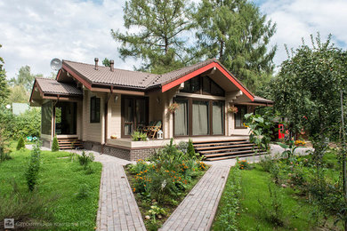 Стильный дизайн: одноэтажный, деревянный, бежевый дом среднего размера в современном стиле с двускатной крышей - последний тренд