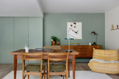 Cette image montre une grande salle à manger vintage avec un mur vert, parquet clair et aucune cheminée.