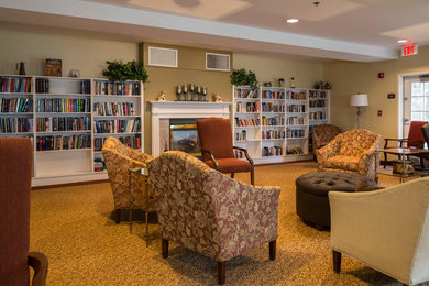 Living room library - mid-sized enclosed carpeted living room library idea with beige walls, a standard fireplace, a wood fireplace surround and no tv