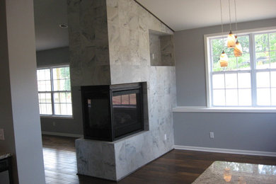 Trendy open concept dark wood floor living room photo in Other with gray walls, a ribbon fireplace, a stone fireplace and no tv