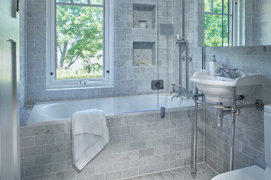 Design ideas for a small traditional master bathroom in Adelaide with a drop-in tub, a shower/bathtub combo, a one-piece toilet, gray tile, stone tile, grey walls, marble floors and a console sink.