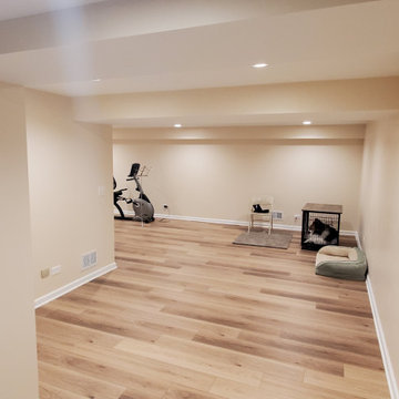 Fully remodeled 1970s finished basement with luxury vinyl plank flooring and can