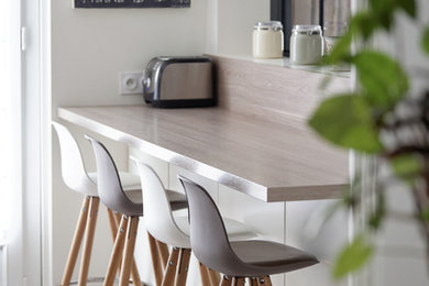 Inspiration pour une grande cuisine parallèle et encastrable design fermée avec un évier encastré, un placard à porte plane, des portes de placard blanches, un plan de travail en stratifié et aucun îlot.