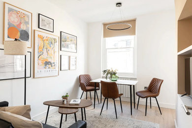 Photo of a medium sized contemporary cream and black and formal open plan living room feature wall in London with beige walls, light hardwood flooring, no fireplace, beige floors, a drop ceiling and a concealed tv.