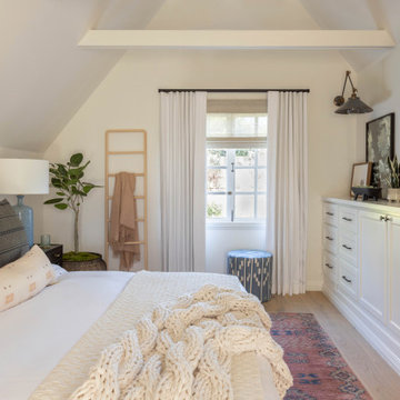 Bedroom with Built-In Storage, Articulating Sconce, and Vaulted Ceiling