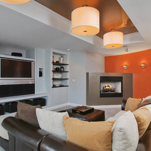 Design ideas for a contemporary fully buried basement in Philadelphia with a corner fireplace, orange walls, a metal fireplace surround, carpet and grey floors.