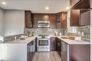 Example of a mid-sized classic u-shaped laminate floor and black floor kitchen design in Salt Lake City with a single-bowl sink, shaker cabinets, brown cabinets, quartzite countertops and white countertops