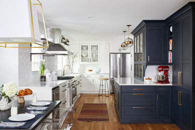 Inspiration for a mid-sized transitional u-shaped medium tone wood floor and orange floor eat-in kitchen remodel in DC Metro with shaker cabinets, blue cabinets, quartz countertops, white backsplash, subway tile backsplash, stainless steel appliances, a peninsula, white countertops and an undermount sink