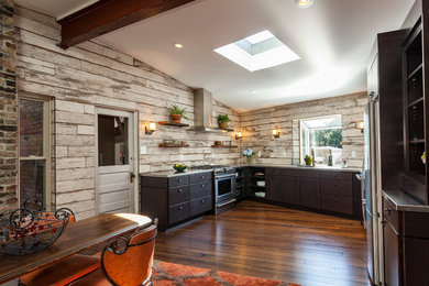 Example of a mid-sized urban u-shaped dark wood floor and brown floor eat-in kitchen design in Other with no island, flat-panel cabinets, dark wood cabinets, stainless steel countertops, an integrated sink, white backsplash, wood backsplash and stainless steel appliances