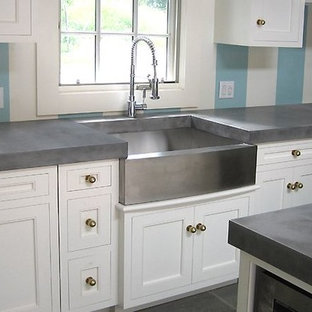 This is an example of a transitional kitchen in Orlando with a farmhouse sink, beaded inset cabinets, white cabinets, concrete benchtops, stainless steel appliances and with island.
