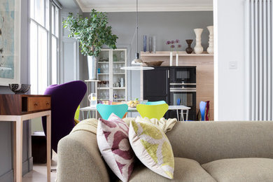 Inspiration for a medium sized contemporary open plan living room with a music area, grey walls, light hardwood flooring, a hanging fireplace, a freestanding tv and beige floors.