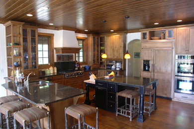 Elegant u-shaped dark wood floor eat-in kitchen photo in Indianapolis with a double-bowl sink, recessed-panel cabinets, medium tone wood cabinets and an island