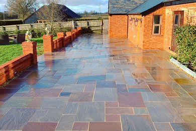 Design ideas for a large country courtyard patio in Essex with natural stone paving.