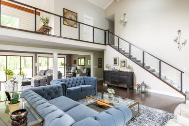 Example of a large trendy open concept dark wood floor and brown floor family room design in Other with beige walls