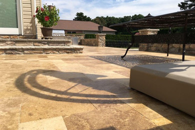 Inspiration for a mid-sized timeless backyard stone patio kitchen remodel in New York