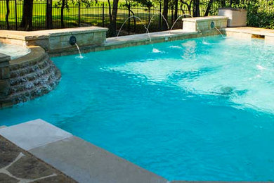 Hot tub - mid-sized backyard concrete paver and custom-shaped lap hot tub idea in Dallas