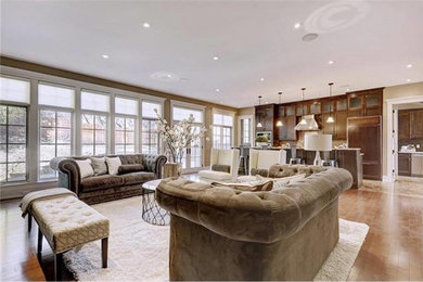 Example of a large trendy open concept medium tone wood floor and brown floor living room design in Orange County with brown walls