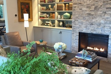 Example of a mid-sized trendy medium tone wood floor living room design in Los Angeles with a music area, gray walls, a standard fireplace, a stone fireplace and a media wall