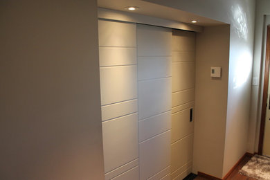 Photo of a modern gender-neutral built-in wardrobe in Montreal with medium hardwood floors and brown floor.