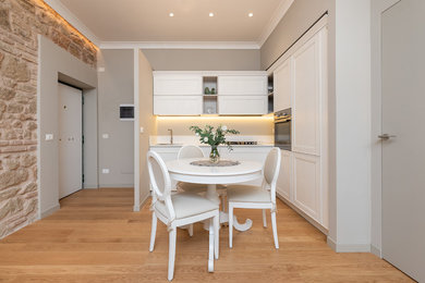 Ispirazione per una cucina chic con lavello a vasca singola, ante con riquadro incassato, ante bianche, elettrodomestici in acciaio inossidabile, parquet chiaro, nessuna isola, pavimento beige, top bianco e paraspruzzi bianco