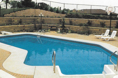 Inspiration for a backyard brick and custom-shaped pool house remodel in New York