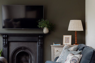This is an example of a medium sized traditional living room in Belfast with green walls.