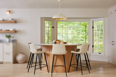 Foto de comedor de cocina minimalista de tamaño medio con paredes blancas, suelo de madera clara y suelo beige