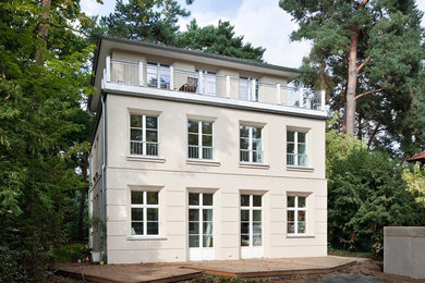 Zweistöckiges Klassisches Einfamilienhaus mit Putzfassade, beiger Fassadenfarbe, Walmdach und Ziegeldach in Berlin