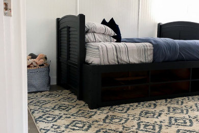 Example of a farmhouse medium tone wood floor and brown floor bedroom design in Atlanta with white walls