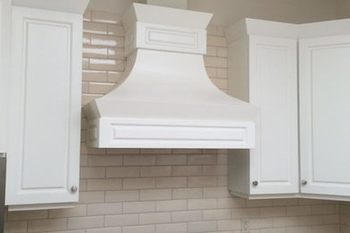 Mid-sized transitional u-shaped eat-in kitchen photo in Other with raised-panel cabinets, white cabinets, granite countertops, beige backsplash, subway tile backsplash, black appliances and multicolored countertops