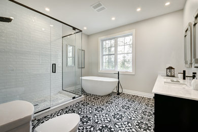 Example of a minimalist white tile and ceramic tile ceramic tile, multicolored floor and double-sink bathroom design in Los Angeles with flat-panel cabinets, black cabinets, a one-piece toilet, beige walls, a drop-in sink, quartzite countertops, a hinged shower door, beige countertops and a built-in vanity