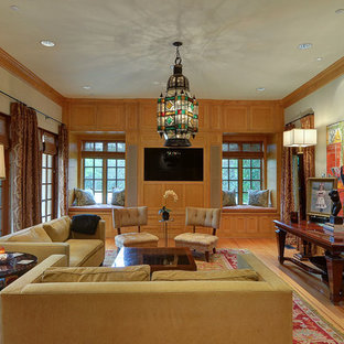 Ejemplo de salón mediterráneo con paredes grises, suelo de madera en tonos medios, televisor colgado en la pared y suelo marrón