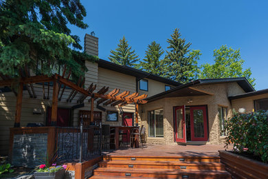 Patio kitchen - large traditional backyard patio kitchen idea in Calgary with decking and a pergola